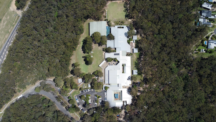 An aerial dron shot of the high school showing surrounding bushland and lush green playgrounds